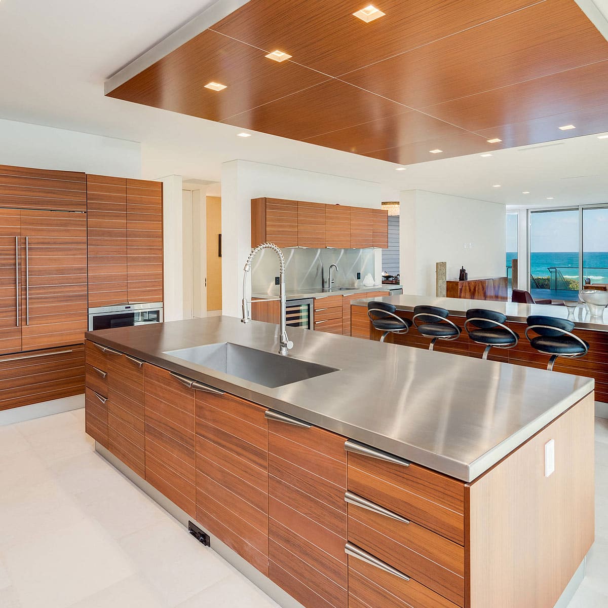 Modern kitchen with stainless steel countertops and wood cabinetry.